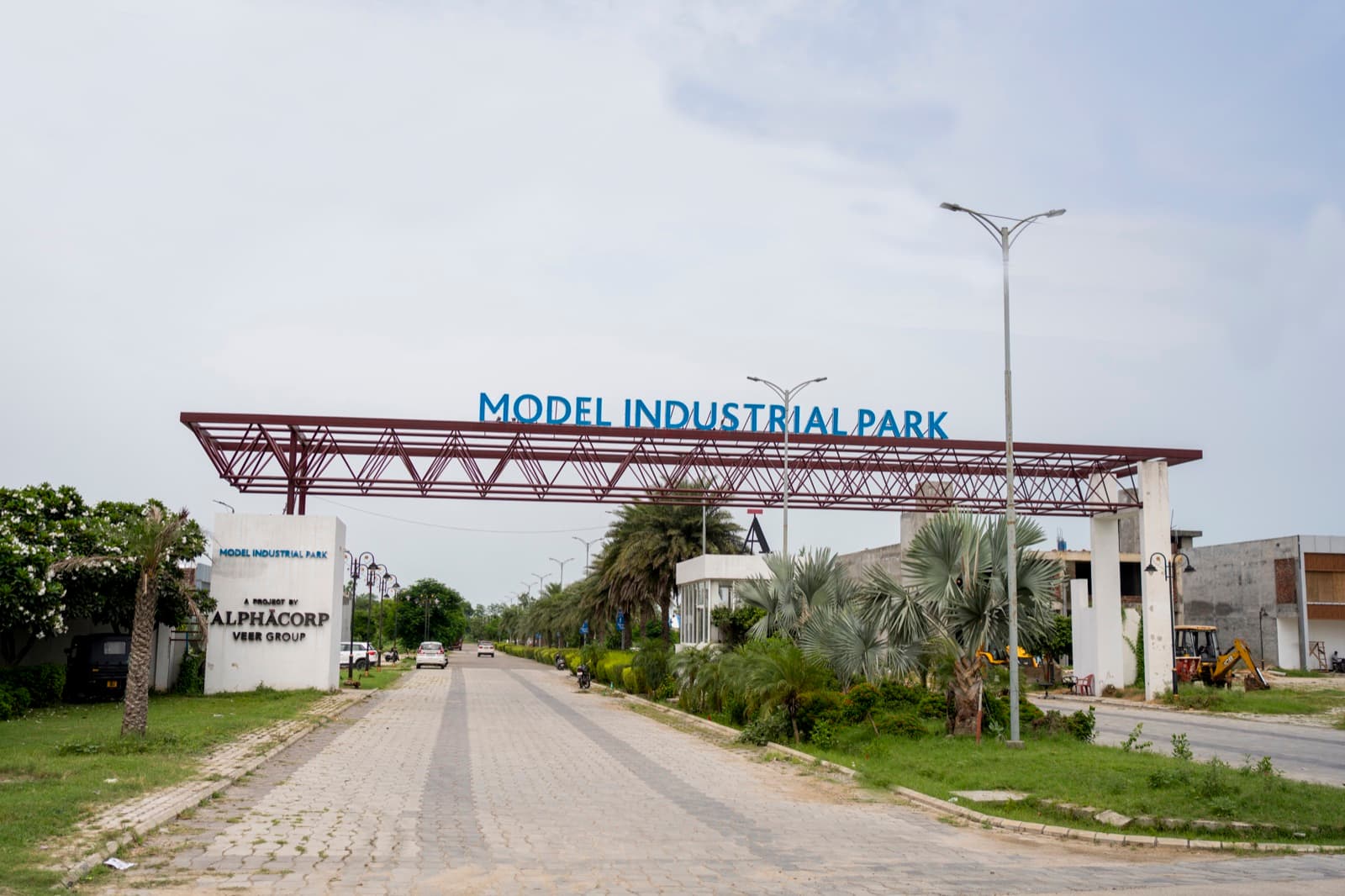 The Model Industrial Park gantry spanning the entrance road, with the AlphaCorp pillar alongside